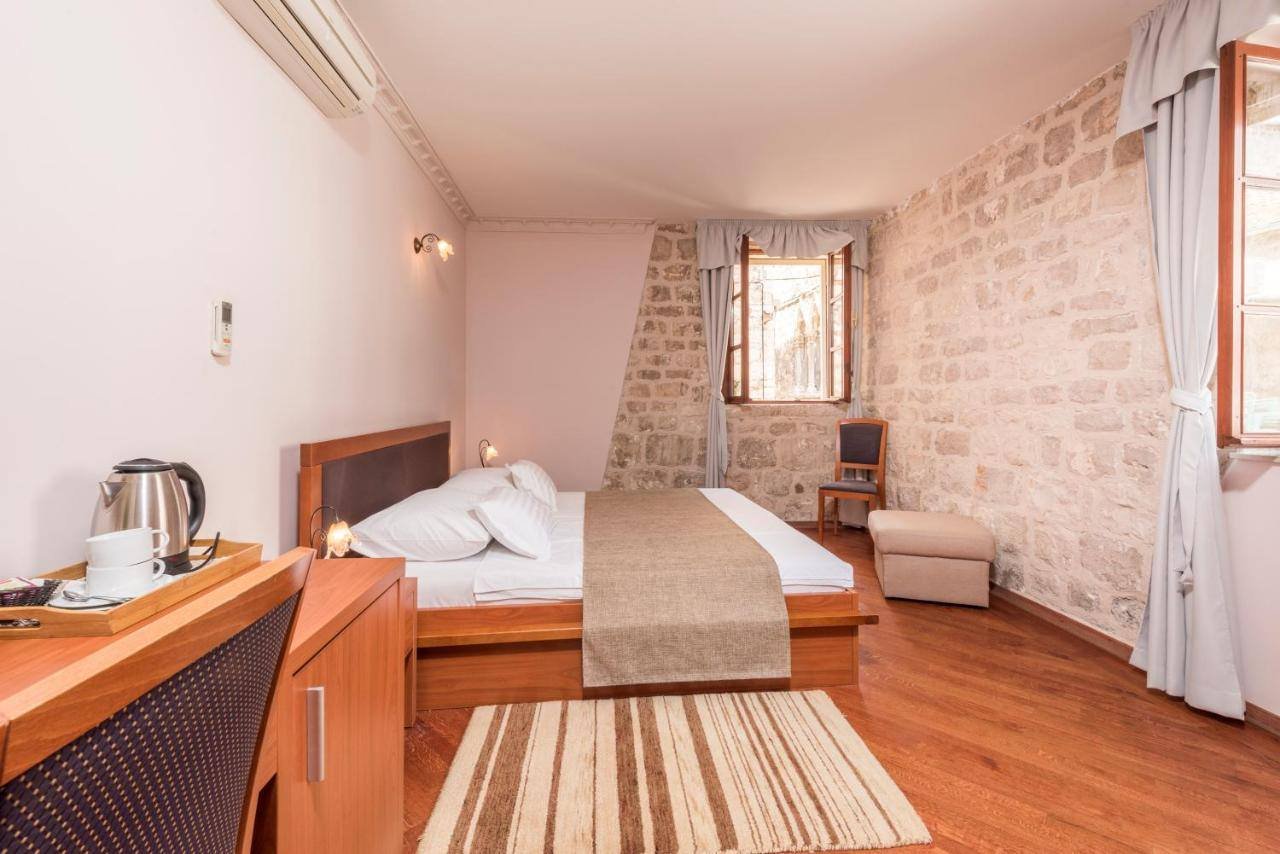 Villa Nora Hvar: room with a double bed, a kettle and a stone wall